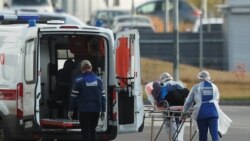 Медработники переносят пациента с COVID-19 в машину скорой помощи в Москве. 15 октября 2020 года.