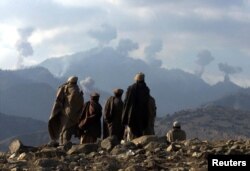 Talybanlara garşy durýan ýerli owgan topary Tora Bora daglarynda koalision güýçleriň geçirýän hüjümlerine syn edýär.