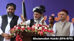 President Ashraf Ghani (center) stands with Amrullah Saleh (right), his vice presidential candidate, during his election campaign stop in Jalalabad on September 20.