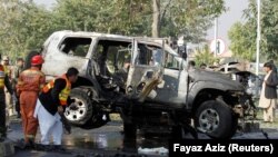 Rescue personnel inspect a vehicle damaged by a suicide bomber that killed a senior Pakistani police official on his way to work in Peshawar on November 24.