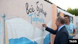 Президент России Владимир Путин (на первом плане) во время посещения Всероссийского молодежного форума «Таврида на Бакальской косе». Крым, 19 августа 2016 года. 