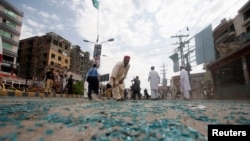 Rescue workers and cleanup crew members work at the site of the bomb blast on University Road in Peshawar on April 29.