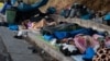 Refugiați și migranți, dormind la marginea unui drum, pe insula Lesbos, Grecia