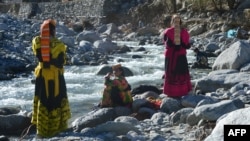 Kalash women wash their clothes in a stream near the village of Bumburate. 