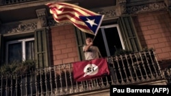 Мужчина держит эстеладу – неофициальный флаг каталонских земель. Барселона, 1 октября 2017 года