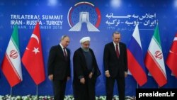 Iran's President Hassan Rouhani (C), flanked by Russia's President Vladimir Putin (L), and Turkey's President Recep Tayyip Erdogan, after posing for photographs in Tehran, Iran, ahead of their summit to discuss Syria, Friday, Sept. 7, 2018.