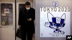 Токио метросында маска киіп тұрған адам. 31 қаңтар 2020 жыл.