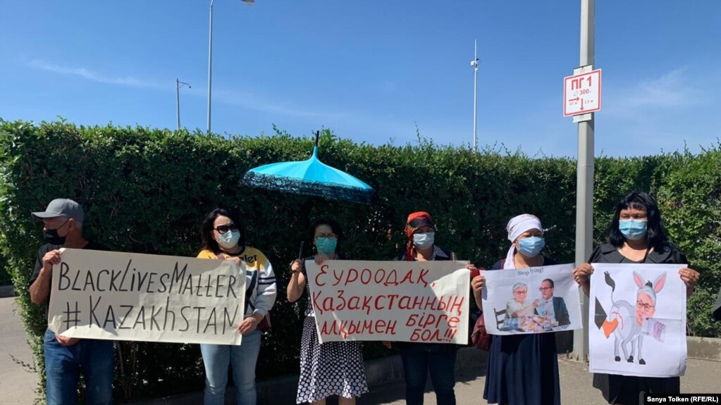 Участники акции протеста с плакатами у здания представительства ЕС в Нур-Султане.