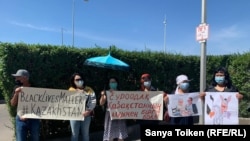 Участники акции протеста с плакатами у здания представительства ЕС в Нур-Султане.