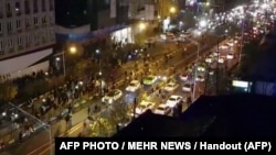 Iran -- An image grab taken from a handout video released by Iran's Mehr News agency reportedly shows a group of men walking down a street in Tehran on December 30, 2017. Ten people died overnight in fresh unrest in Iran, local media reported on January 1