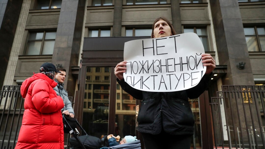 A protester holds a poster reading, "No lifelong dictatorship" while standing in a one-man picket at the State Duma in Moscow on March 13.