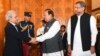 Pakistani President Mamnoon Hussain (center) shakes hands with new caretaker Prime Minister Nasir-ul Mulk in Islamabad on June 1.