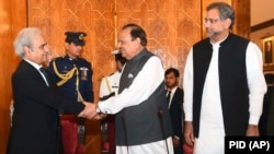 Pakistani President Mamnoon Hussain (center) shakes hands with new caretaker Prime Minister Nasir-ul Mulk in Islamabad on June 1.