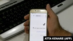 Muškarac drži mobitel konektovan na WiFi mrežu bez pristupa internetu u kancelariji u Teheranu 17. novembra.