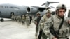 U.S. soldiers leave a plane as they arrive from Afghanistan at the Manas air base in February 2009.