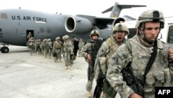 U.S. soldiers leave a plane as they arrive from Afghanistan at the Manas air base in February 2009.