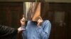 Syed Mustafa H. from Pakistan covers his face as he attends the start of his trial in Berlin, March 8, 2017