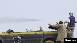 NTC fighters watch a rocket flying past outside Sirte airport on September 30.