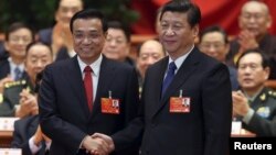 Кытайдын жекшембиде шайланган премьери Ли Кацян президент Си Цзиньпин менен кол алышууда.