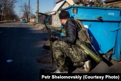 Un separatist de pază în apropiere de aeroportul din Donețk, controlat de forțele Kievului.