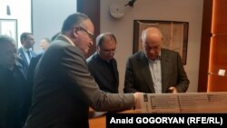 Директор Музея денег Астамур Тания показывает Аслану Бжания и Сергею Шамба монеты