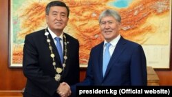 Қырғызстан президенті Сооронбай Жээнбеков (сол жақта) өзін ұлықтау салтанатында экс-президент Алмазбек Атамбаевтың қолын алып тұр. Бішкек, 24 қараша 2017 жыл.