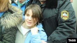 Екатерина Самуцевич, участница панк-группы Pussy Riot, покидает здание суда с полицейским. Москва, 10 октября 2012 года. 