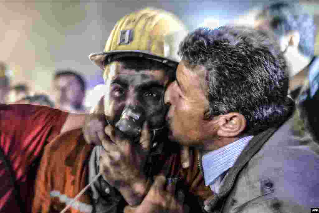 A man kisses his son, who survived an explosion in a coal mine in Manisa, Turkey, which killed hundreds of people on May 13. (AFP/Bulent Kilic)