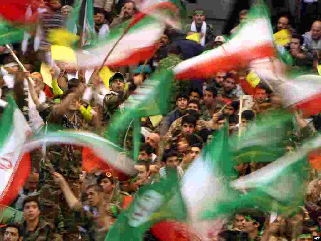Members of the Basij militia wave Iranian flags at a ceremony marking the 30th anniversary of the group's establishment - Photo by Atta Kenare for AFP