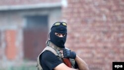 File photo of a Pakistani security official standing guard near the site of a suicide bomb blast during an operation against militants in Lahore.