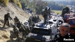 Kosovo - A Kosovo Serb man sits on a truck in front of Kosovo Force (KFOR) soldiers from Germany in the village of Jagnjenica near the town of Zubin Potok, 20Oct2011