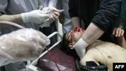 Medics treat an injured man who later died from his wounds at a hospital in Deraa 