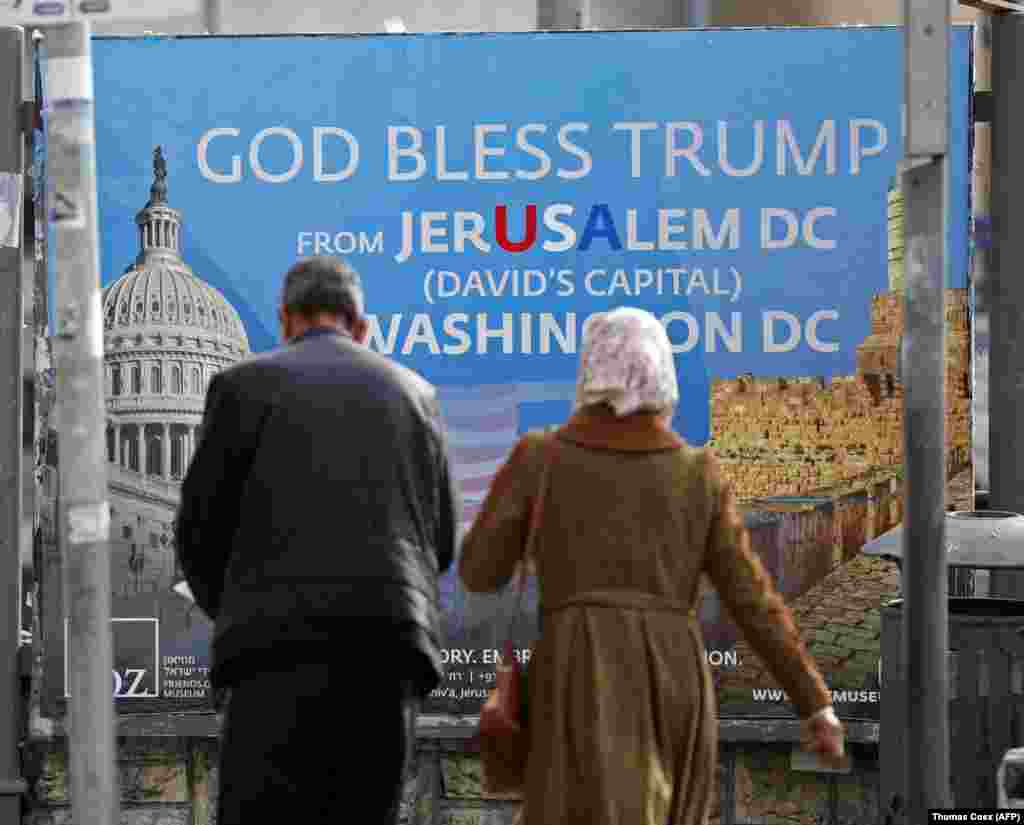 ИЗРАЕЛ - Палестинска двојка поминува покрај билборд со порака од произраелскота евангелистичка група пријатели на Зајон: Господ да го благослови Трамп! Нападите на милитантните муслимански групи врз израелски цели и врз израелските безбедносни сили, а по одлуката на американскиот претседател да го признае Ерусалим за главен град на Израел продолжија, на што најостро реагираше израелската авијација која срамнила со земја неколку важни пунктови на орханизацијата Хамас.