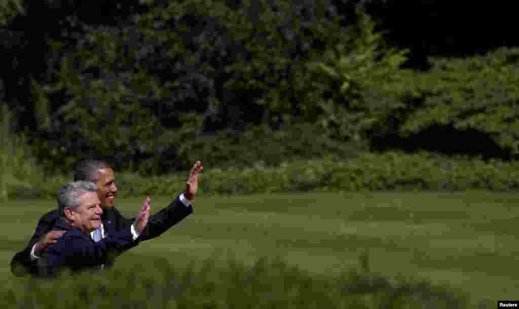 U.S. President Barack Obama and his German counterpart, Joachim Gauck, wave as they stroll in the park of Bellevue Castle in Berlin. Obama will unveil plans for a sharp reduction in nuclear warheads in a landmark speech at the Brandenburg Gate on June 19. (Reuters/Wolfgang Rattay)