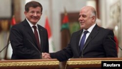 رئيس الوزراء العراقي حيدر العبادي يصافح نظيره التركي أحمد داودأوغلو