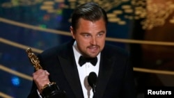 Леонардо Ди Каприо держит награду, 28 февраля 2016 г.