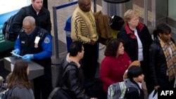 An official checks passengers' identification prior to entering a security checkpoint at Ronald Reagan Washington National Airport in Arlington, Virginia.