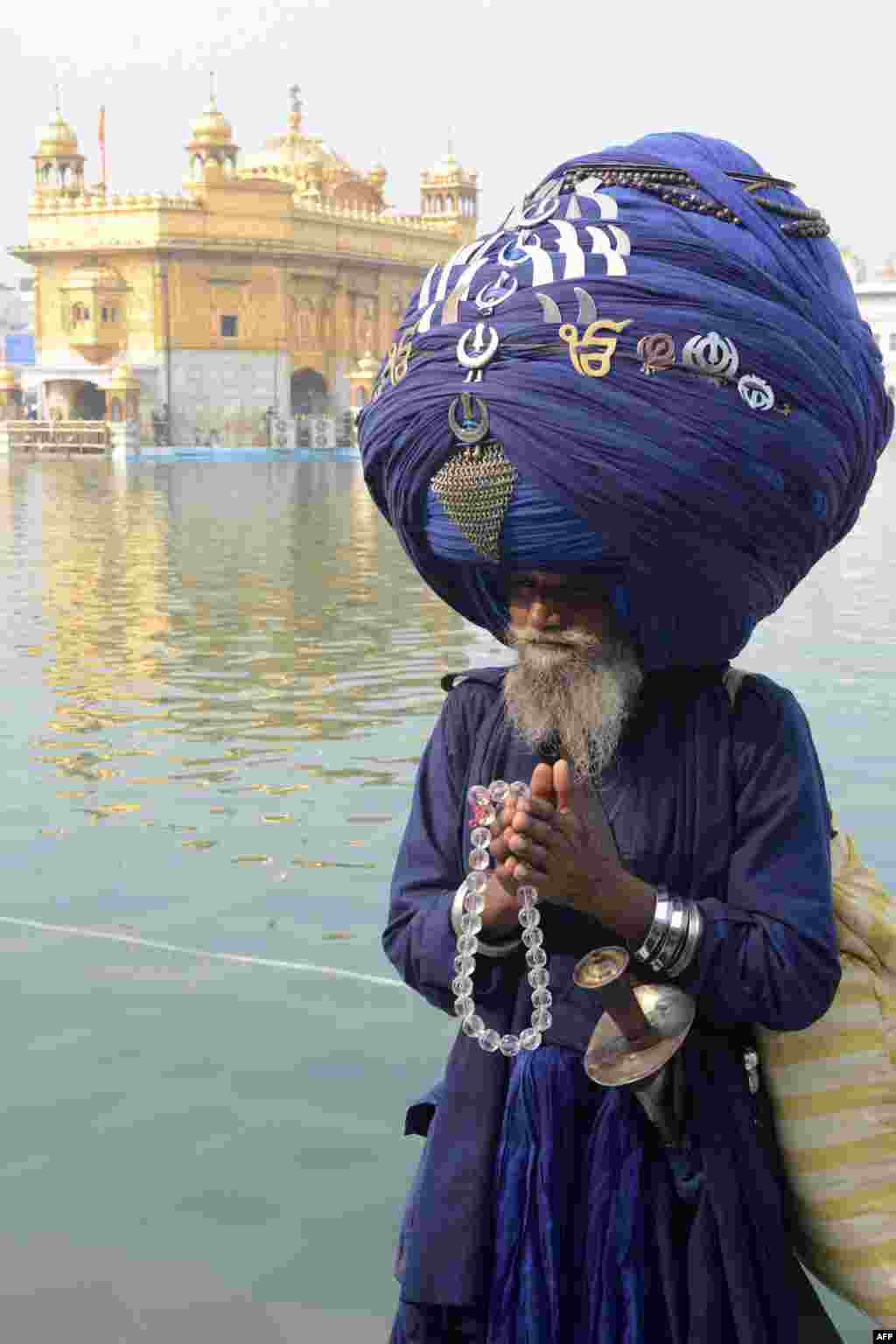 An Indian member of the Sikh Nihang Army wears a turban of more than 300 meters in length at the Maghi Mela festival at the Sikh Shrine Golden Temple in Amritsar, India. Maghi Mela follows the Lohri or harvest festival and commemorates fighters in the Battle of Khidrana fought between the Mughal Army and the 10th Sikh Guru, Gobind Singh Ji. (AFP/Narinder Nanu)