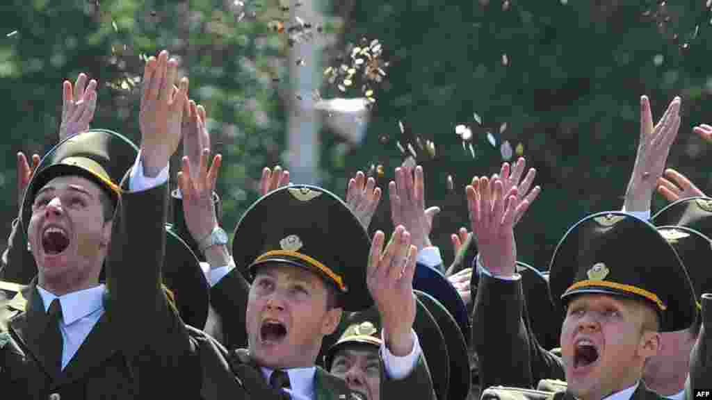 Belarusian cadets throw coins in the air during a graduation ceremony at the Military Academy outside Minsk on July 1. (AFP/Viktor Drachev)