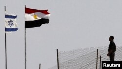 Egypt -- A soldier stands near the Egyptian national flag and the Israeli flag at the Taba crossing, 26Oct2011