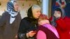 A group of women comfort each other after a memorial service in the Russian Orthodox Church in Kizlyar for the victims of a mass shooting in the city in February 18.