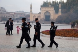 Патруль спецподразделения китайской полиции безопасности на площади перед мечетью Ид Ках в Кашгаре.