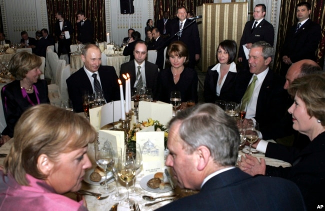 Putin (secondo a sinistra dietro), il presidente degli Stati Uniti George W. Bush (a destra) e il cancelliere tedesco Angela Merkel (davanti a sinistra) partecipano a un ricevimento a Bucarest, in Romania, il 3 aprile 2008, nell'ambito del vertice della NATO.
