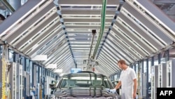 A Volkswagen employee polishes a VW Phaeton at the car company's "transparent" factory in Dresden.