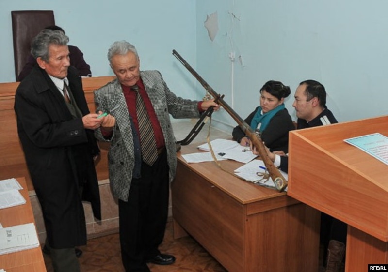 Истец Толеген Сагындык (слева) с адвокатом демонстрируют в суде ружейную приставку, которая принадлежала его предку. Атырау, ноябрь 2009 года