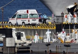 Медики швидкої допомоги та берегової охорони Японії в захисному спорядженні готуються до транспортування заражених пасажирів, які перебували на борту круїзного лайнера Diamond Princess, у порту Йокогама, 5 лютого 2020 року