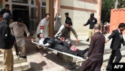 Vullnetarët pakistanezë duke i ndihmuar të plagosurit nga sulmi i sotëm vetëvrasës afër një spitali në qytetin Kueta 