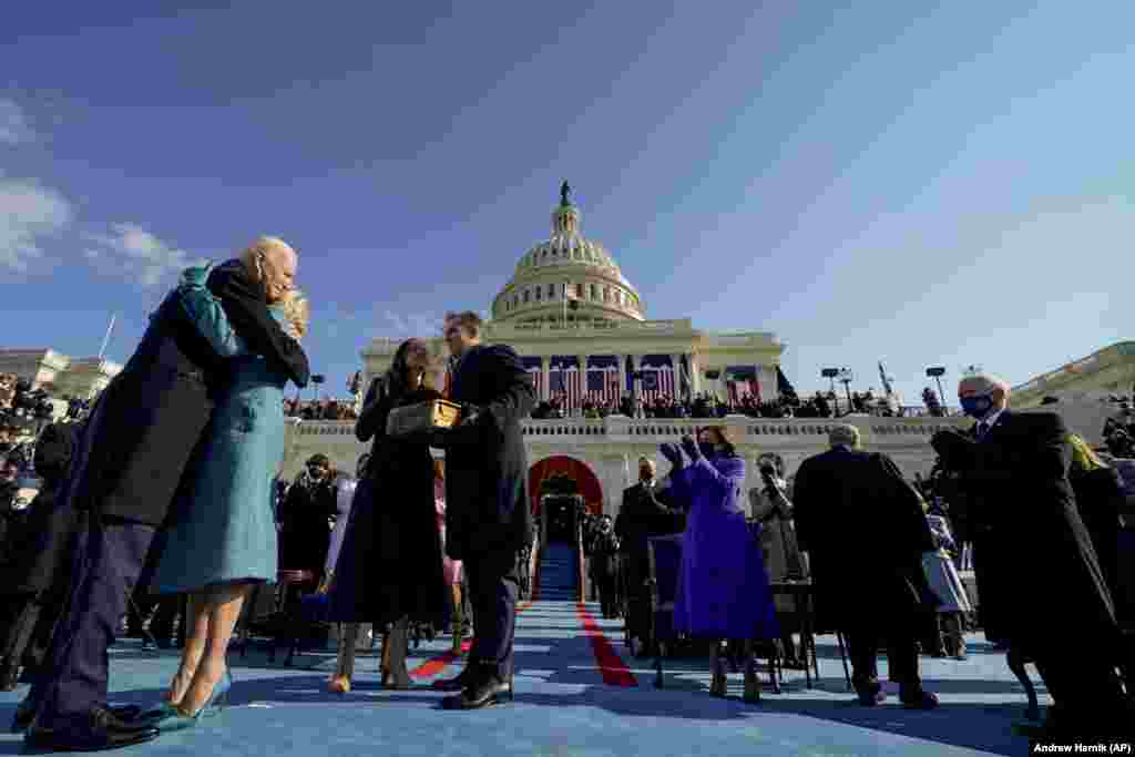 Ish-nënpresidenti amerikan Mike Pence (djathtas) duartroket ndërsa Joe Biden përqafon Zonjën e Parë Jill Biden pas betimit si presidenti i 46-të i Shteteve të Bashkuara.