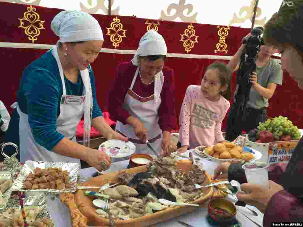 Жительница поселка Бейнеу Алмагуль Есбергенова (слева) привезла на ярмарку и казахское традиционное блюдо из мяса.&nbsp;