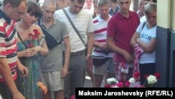 На акции памяти погибшего футбольного фаната возлагали цветы и раздавали черные постеры: "За что убили Юру Волкова?"